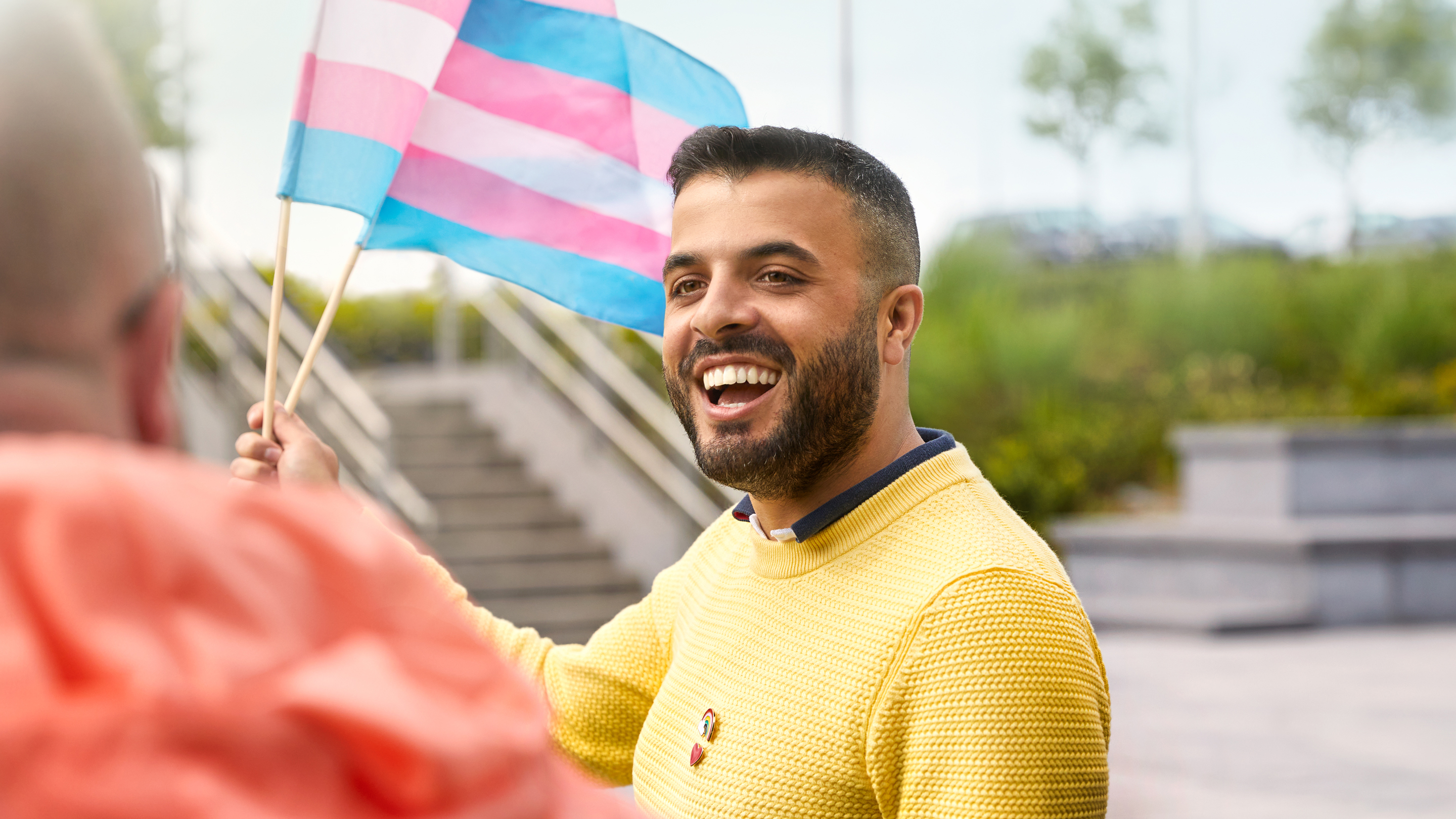 Membre de l’équipe Apple à Cork brandissant un drapeau de la communauté trans.