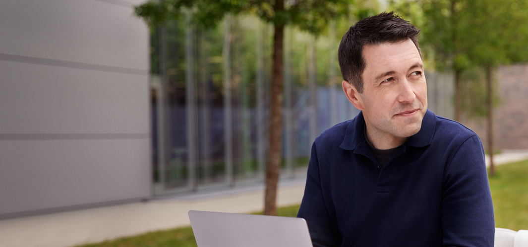Rob assis dehors avec son portable.