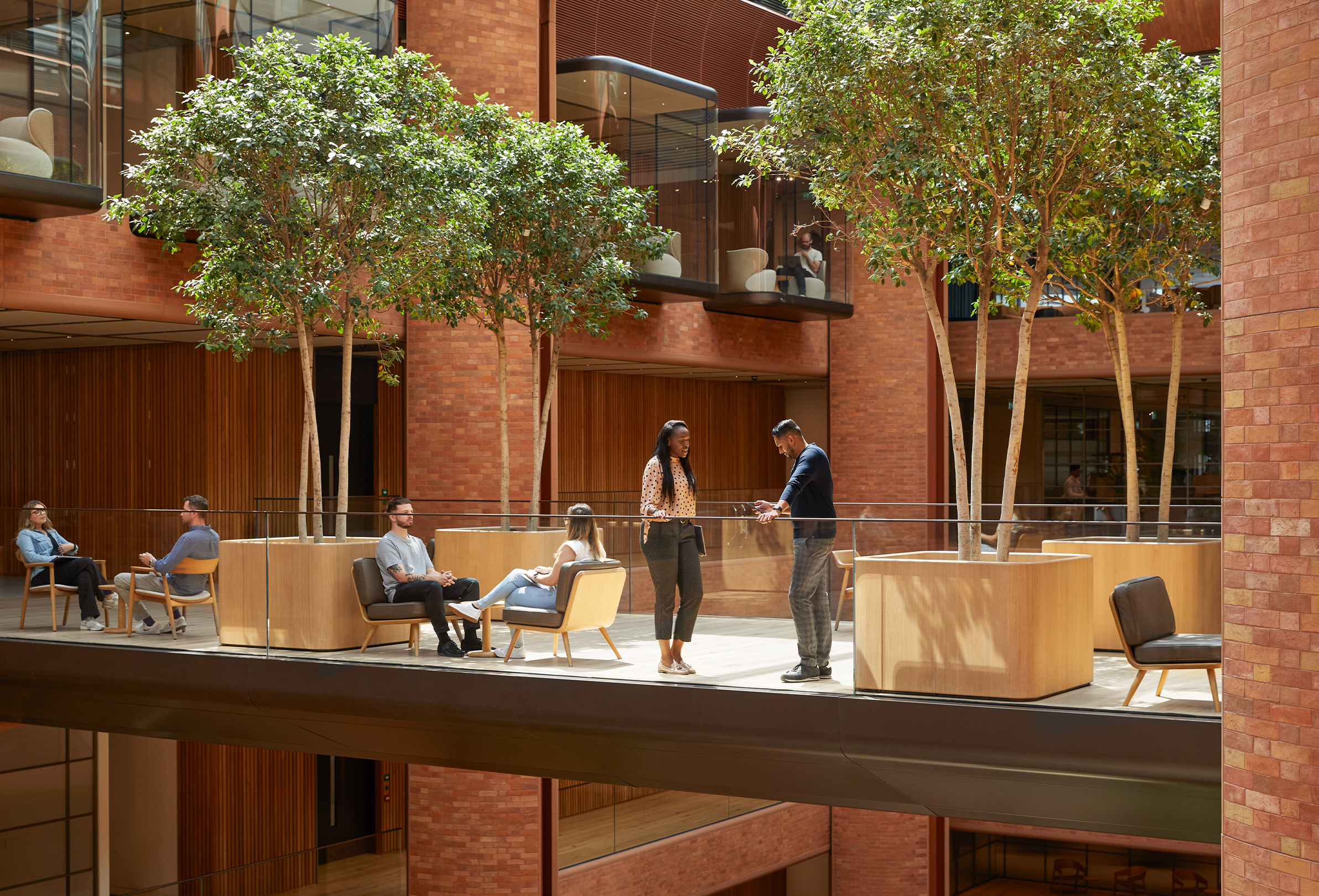 Plusieurs membres de l’équipe Apple menant différentes conversations au sein de l’atrium Battersea.