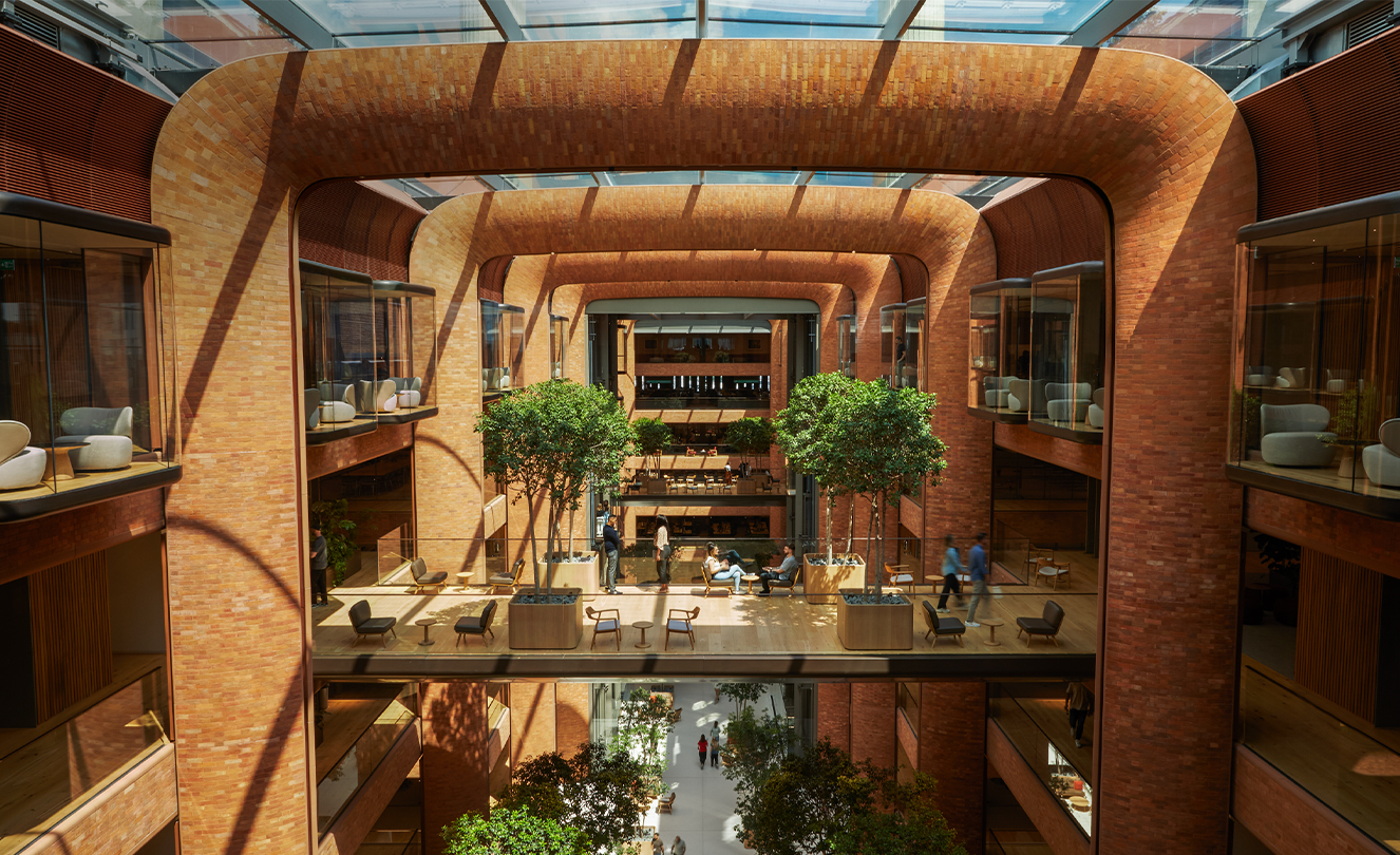 Atrium de cinq étages de Battersea avec le soleil entrant par le toit en verre, éclairant les membres de l’équipe.