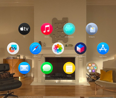 Vue d’accueil de l’Apple Vision Pro. Diverses icônes d’apps flottent dans un espace tridimensionnel dans un salon.