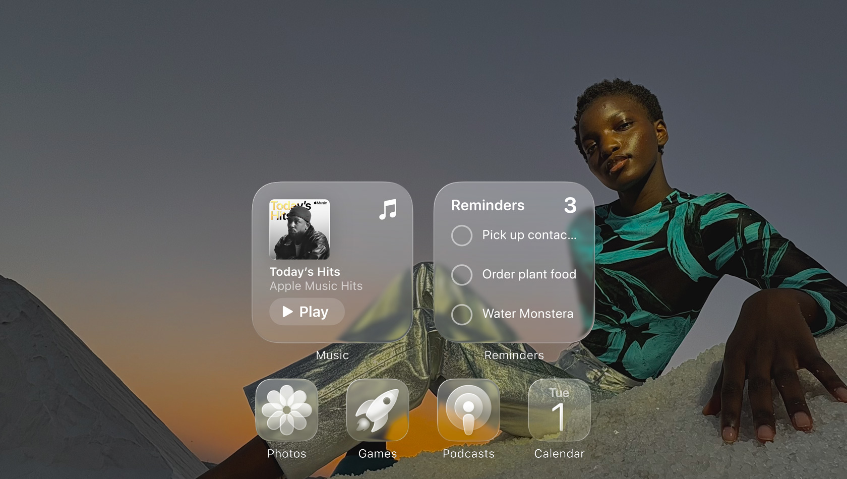 شاشة بتصميم Liquid Glass مع أيقونات شفافة لتطبيقات عدة مثل Apple Music والتذكيرات والصور والألعاب والبودكاست وفيس تايم، وتبدو كلها منعكسة على خلفية الشاشة